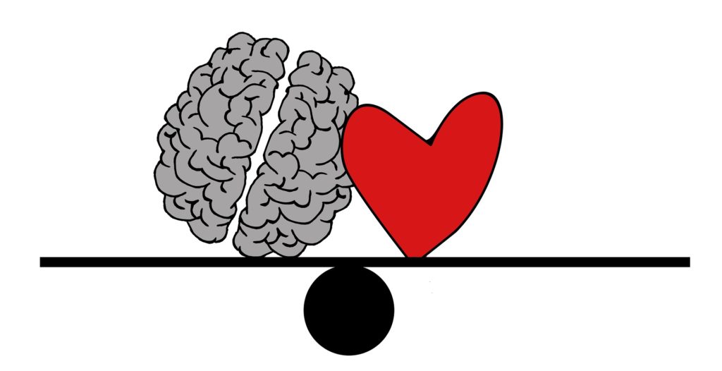Brain and heart balanced on a seesaw to illustrate that content marketing needs to appeal to readers' hearts and minds